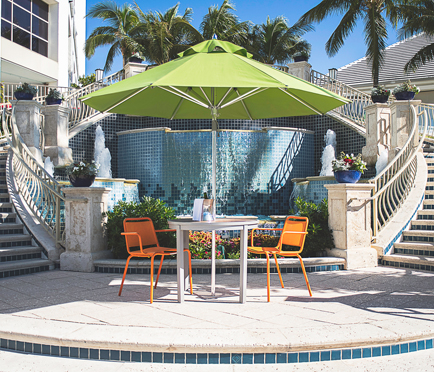 Green Frankford Greenwich Market Umbrella with table and chairs, used in a hospitality setting