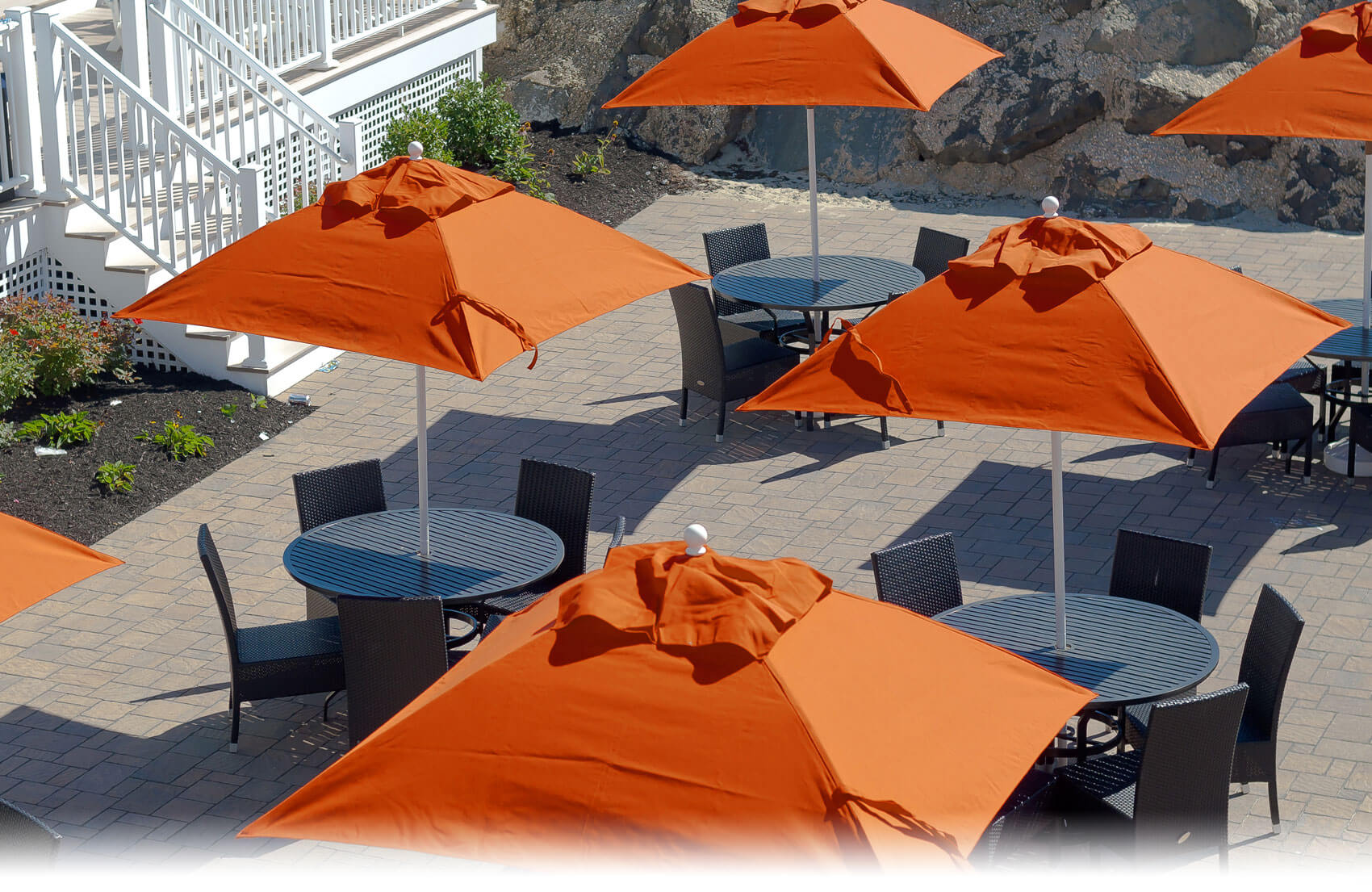 Orange Frankford Market Umbrellas set up over tables at a large property